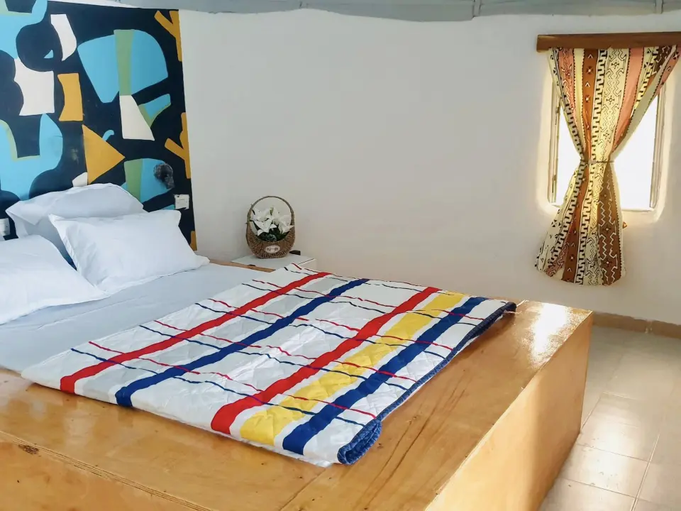 Chambre lumineuse avec fresque abstraite